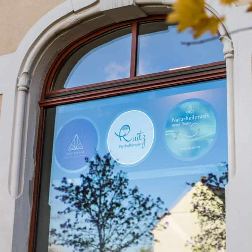 Fensterscheibe der Praxis mit Logos